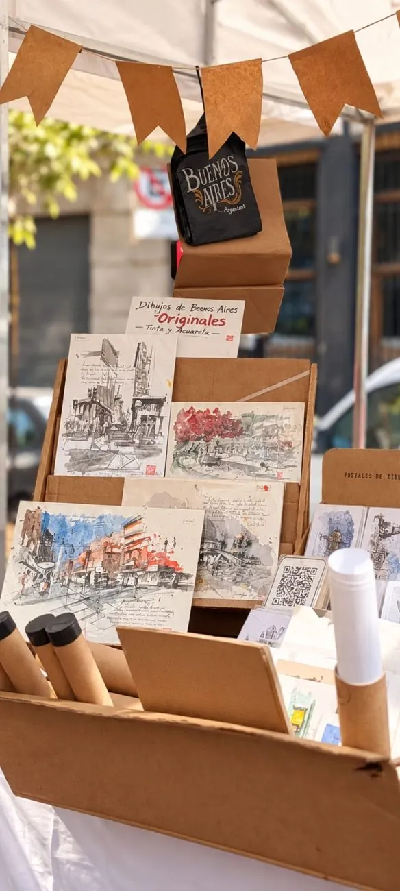 Dibujos originales y postales exhibidos en el puesto