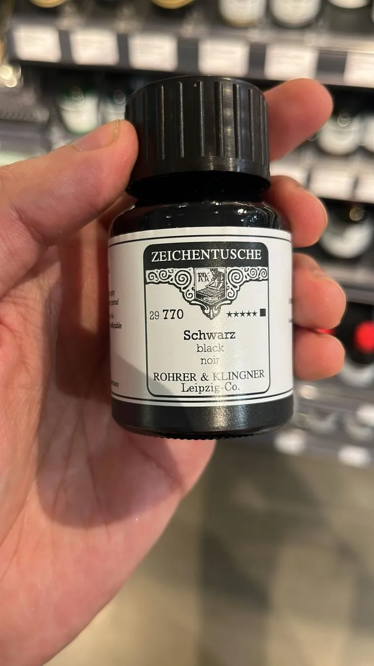 Frasco de tinta china negra Rohrer & Klingner sostenido en la mano