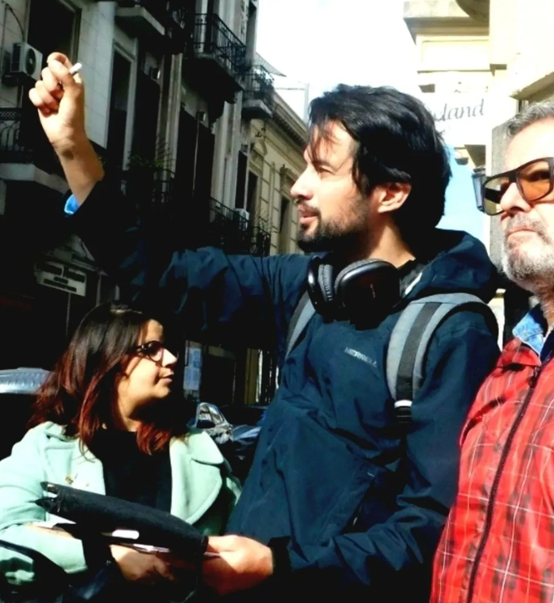 William señalando un edificio durante un recorrido de dibujo, junto a dos participantes